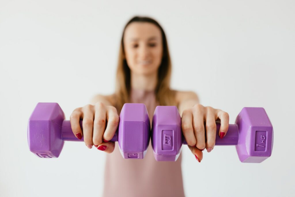 Frau beim Training mit kleinen Hanteln Gewichtsweste Fitnesstraining für Fortgeschrittene