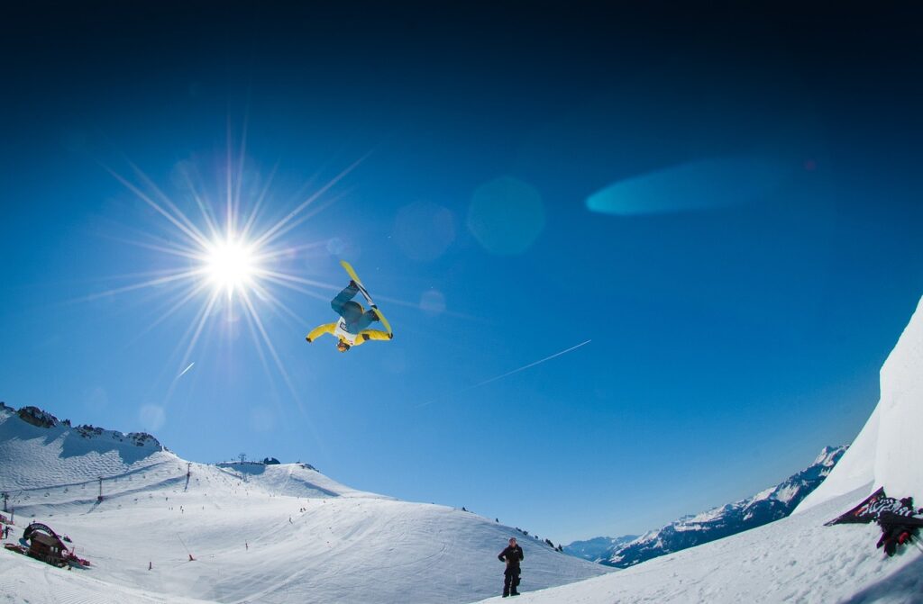 Mann Sprung beim Snowboarden Sonnenschein Piste Welches Snowboard für Tiefschnee Unsere Tipps